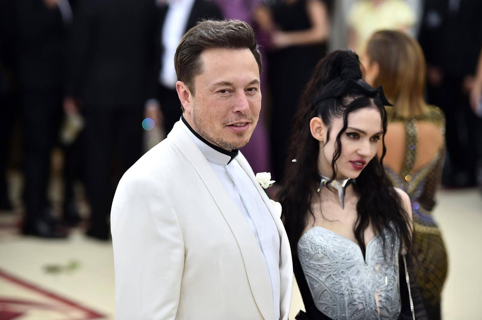 Elon Musk dan Grimes yang tampak berbusana serba putih di red carpet